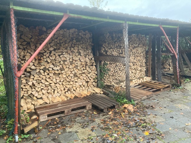 Open bouwwerk waarin houtblokken liggen opgestapeld